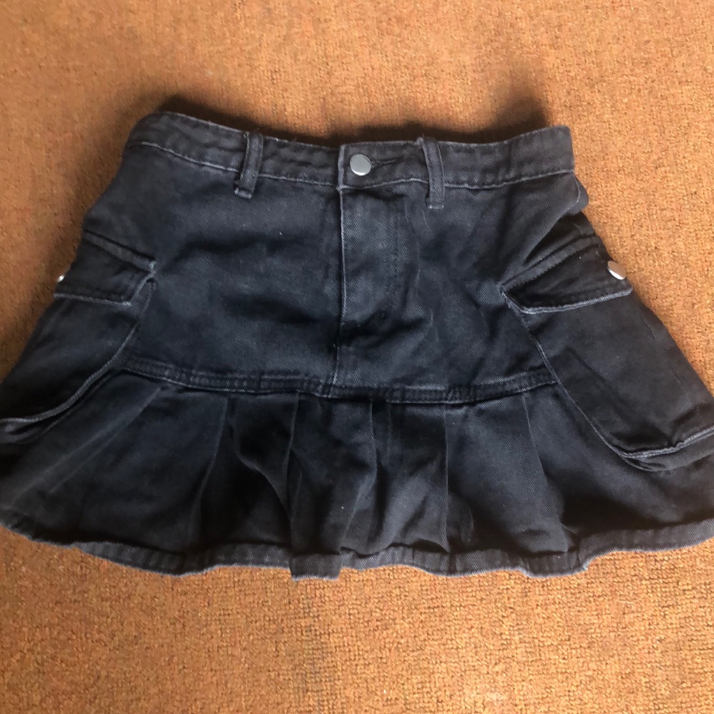 Dark denim cargo mini skirt with pleated panels photographed flat